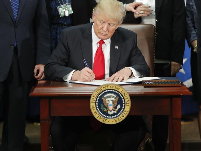 President Donald Trump signs an executive order with a signature that shows no soft curves, but “bigheadedness, anger and fear” experts say. Picture: AP/Martinez Monsivais.