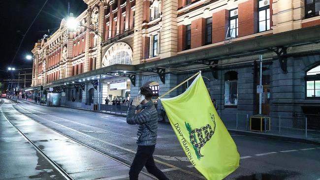 A lone Covid-19 anti-lockdown protestor crosses Flinders St. Picture : Ian Currie