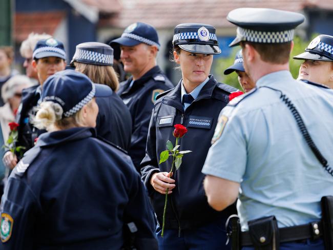 The service in Randwick this morning to remember victims of domestic violence. Police were in attendance, holding a rose is constable Emma Kennedy. Picture: David Swift