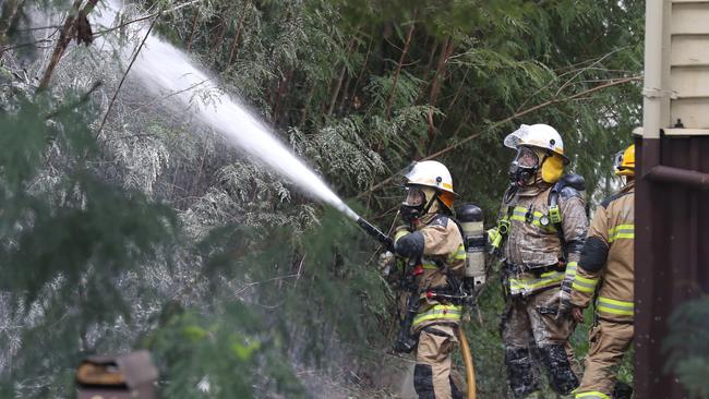 Fire fighters work to salvage the home. Picture: Annette Dew.