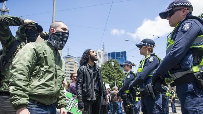 Protesters stare down police at a rally in Melbourne’s CBD. Picture: Eugene Hyland