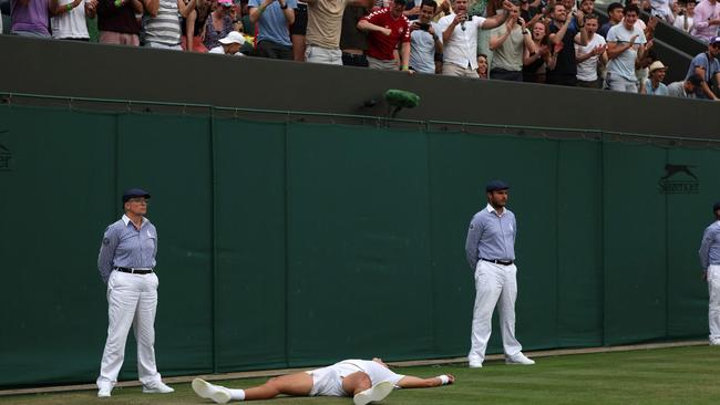 Denmark's Holger Rune lies on the court after beating Spain's Alejandro Davidovich Fokina. Photo by Adrian DENNIS / AFP.