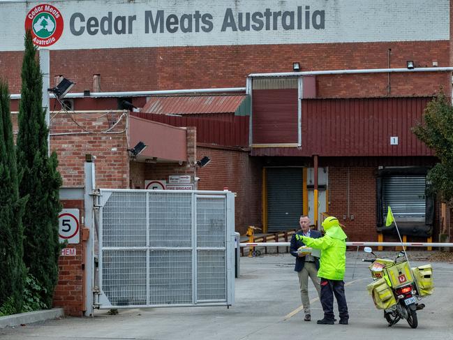 MELBOURNE, AUSTRALIA - MAY 19: A Australia post worker delivers mail to Cedar Meats on May 19, 2020 in Melbourne, Australia. Staff at the Cedar Meats in the Melbourne suburb of Brooklyn have started to return to work from Monday 18 May, as the meat works resumes operation of its cold storage facility. The abattoir was at the centre of a coronavirus (COVID-19) cluster outbreak with 100 cases linked to the site. All 350 onsite staff at Cedar Meats were tested for COVID-19, after one of the abattoir workers tested positive to the virus on April 27. (Photo by Darrian Traynor/Getty Images)