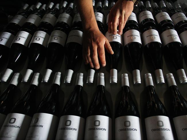 TUMBARUMBA, AUSTRALIA - NOVEMBER 24: Adrian Brayne handles wine stock in the processing building at Obsession Wines on November 24, 2020 in Tumbarumba, Australia. Second-generation winemaker and owner of boutique wine label 'Obsession Wines', Adrian Brayne lost his home, equipment and 10 hectares of vineyards (planted in the 1990s) in what has become known as the Black Summer Bushfires. He was on track for a promising harvest in February of chardonnay, pinot gris, pinot noir and viognier. Nestled in the picturesque countryside of Tumbarumba, a historic timber town on the western edge of the Snowy Mountains, the community faced two large fire fronts that joined together to create a mega-fire in January this year. Adrian remained on the property to fight and subsequently saved his cellar door and processing building. COVID-19 has since compounded the loss with its dramatic impact on the dining, events and tourism industry, nine months on Adrian is facing an estimated 90% financial loss and is living in a mobile van. However, despite the hardships of the past year, Adrian remains positive about the future and continues to clear bushfire affected trees on his land with preparations in place to replant, a process that will take five years to produce grapes. In the short term, he will look to source from local growers and continue to process wine for his label and others, his remaining stock that escaped damage and available online is helping to keep the business moving along with a percentage of proceeds going back to his local community. (Photo by Lisa Maree Williams/Getty Images)