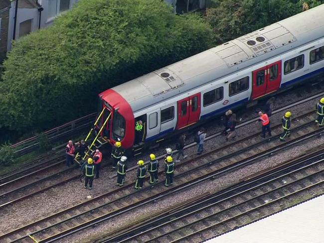 In this aerial image, emergency workers help people to disembark a train near the Parsons Green. Picture: AP