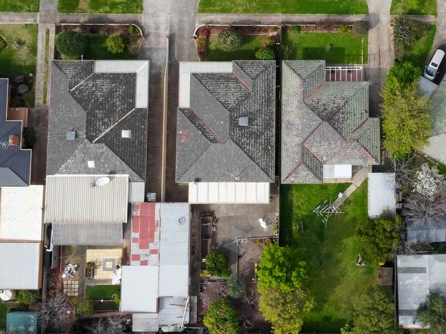 Top down drone view of a small neighborhood of mid-century Australian homes and yards on a quiet street in the outer suburbs of Melbourne