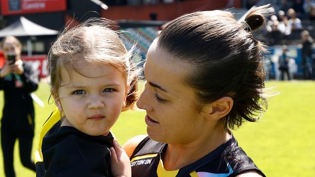 MELBOURNE, AUSTRALIA - OCTOBER 12: Kate Dempsey of the Tigers and daughter Pippa are seen during the 2024 AFLW Round 07 match between the Richmond Tigers and the Geelong Cats at Swinburne Centre on October 12, 2024 in Melbourne, Australia. (Photo by Michael Willson/AFL Photos via Getty Images)