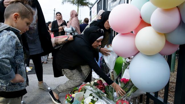 People leaving flowers outside Banksia Road Primary School. Picture: Jonathan Ng