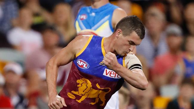 Tom Rockliff of the Lions kisses his black armbands after losing his cousin this season. Picture: Michael Willson/AFL Media/Getty Images