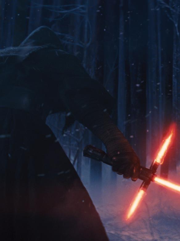 Adam Driver as Kylo Ren with his lightsaber.