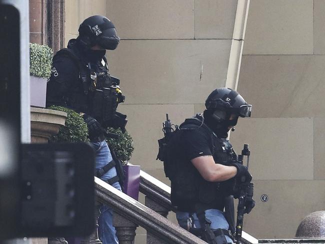 Armed police at the scene of an incident in Glasgow, Scotland, Friday June 26, 2020. Scottish police say the individual shot by armed police during an incident in Glasgow has died and that six other people including a police officer are in hospital being treated for their injuries.  (Andrew Milligan/PA via AP)