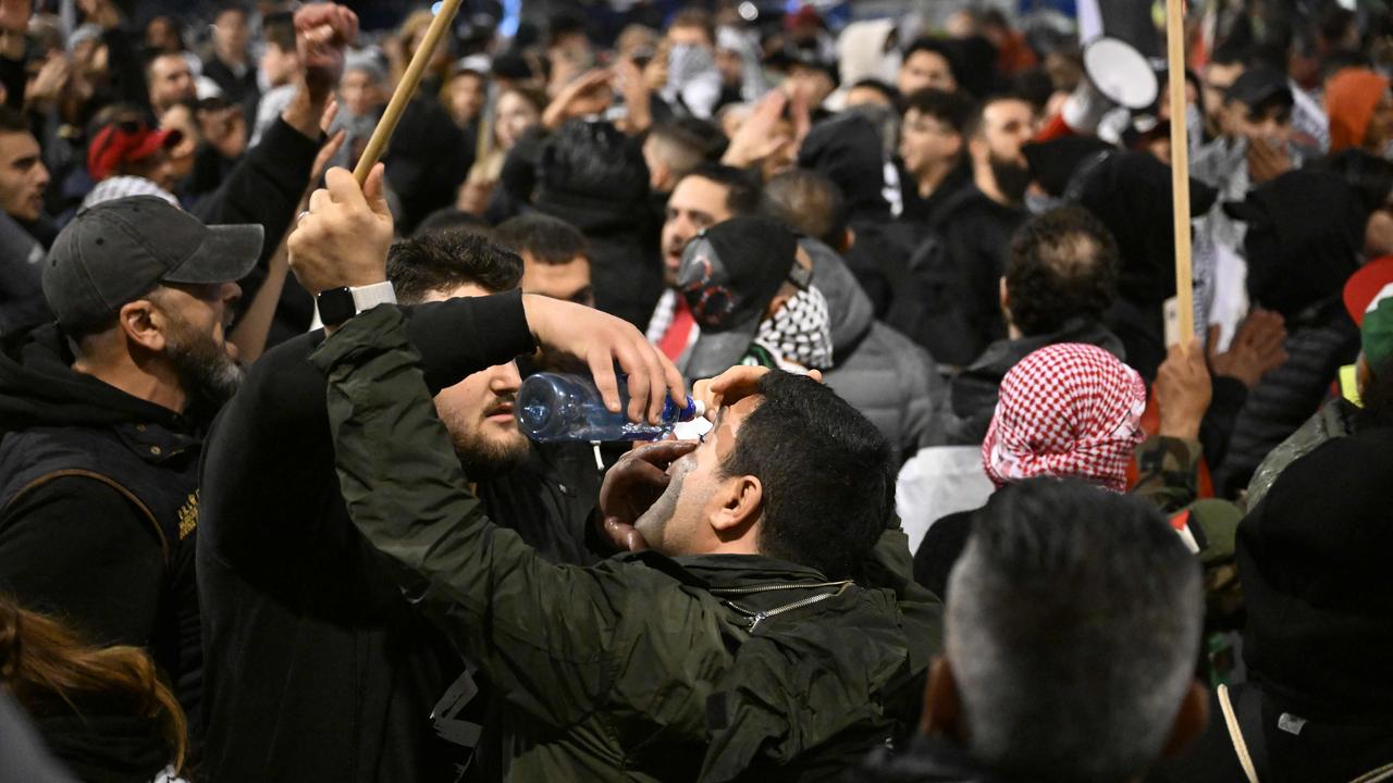 A man washes the eye of another one after police used pepper spray during a pro-Palestinian demonstration.