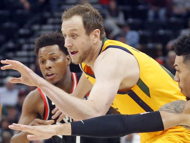 Utah Jazz forward Joe Ingles, center, drives to the basket as Toronto Raptors' Kyle Lowry (7) and Danny Green (14) defend in the first half during an NBA basketball game Monday, Nov. 5, 2018, in Salt Lake City. (AP Photo/Rick Bowmer)