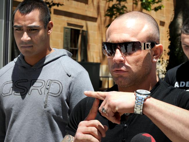 Former gang leader Vince Focarelli gives a time-out gesture outside court during an appearance.