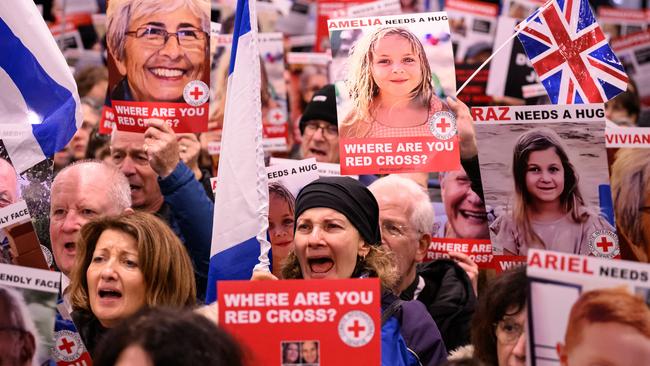 Protesters hold up placards featuring the faces of some of those believed to be being held hostage in Gaza by Hamas, as they hold a rally outside the London offices of the Red Cross. Picture: Getty Images