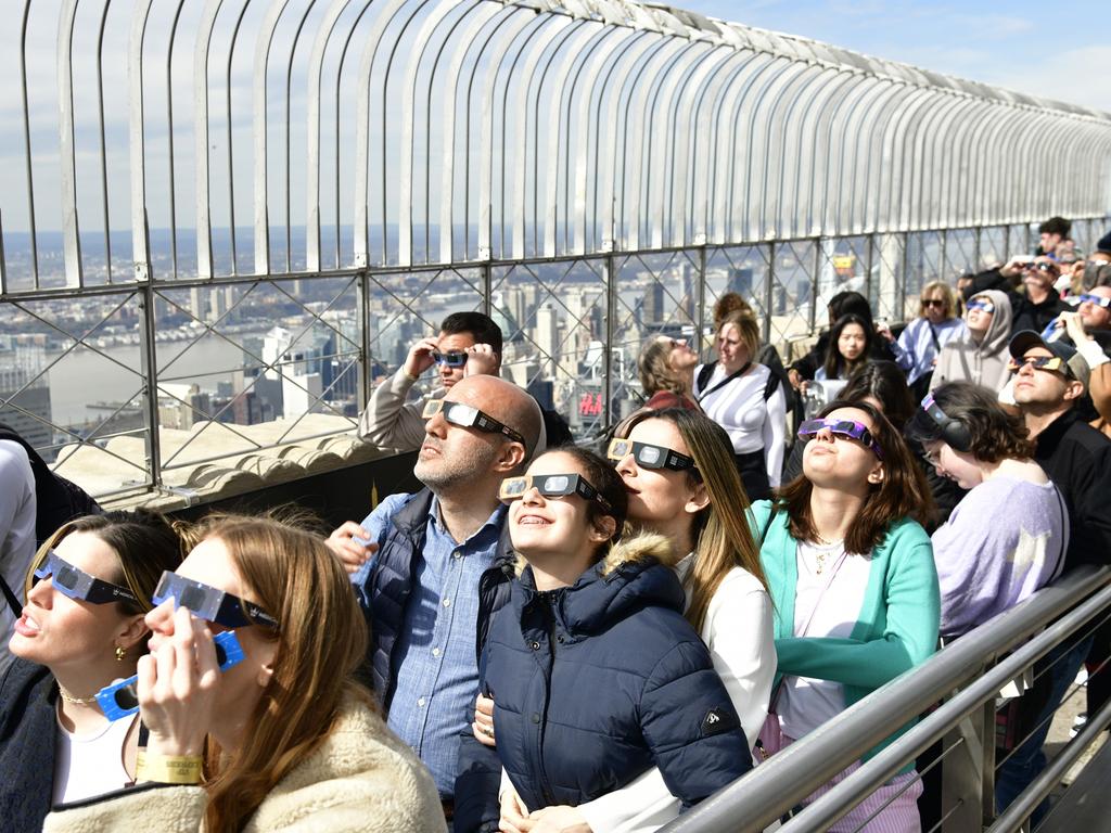 NEW YORK, NEW YORK - APRIL 08: People gather to view the solar eclipse at the Empire State Building on April 08, 2024 in New York City. (Photo by Eugene Gologursky/Getty Images for Empire State Realty Trust)