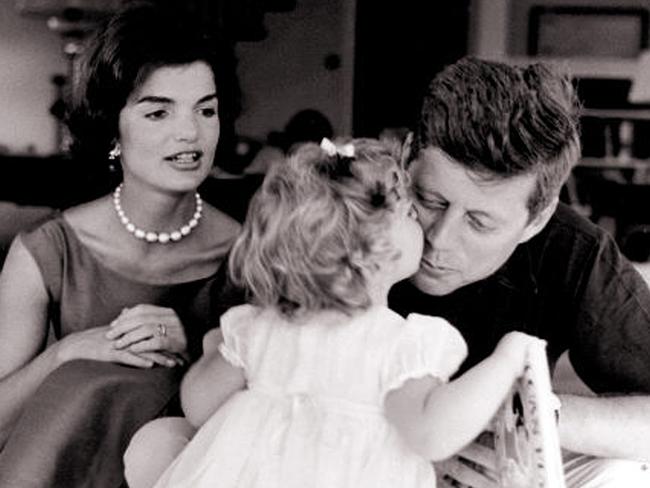 Caroline Kennedy, 2, kissing her father US President John F. Kennedy, while her mother Jackie Kennedy watches on, in Hyannisport, May 23, 1960.
