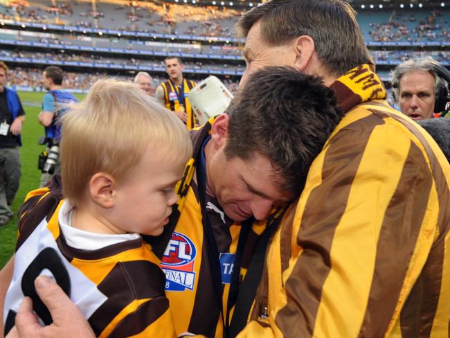 Shane Crawford with son Charlie celebrate the 2008 premiership with Hawthorn president Jeff Kennett.