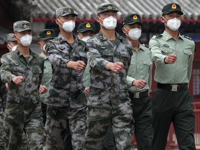 Chinese People's Liberation Army (PLA) soldiers wearing face masks to protect against the spread of the new coronavirus march near the Forbidden City during a plenary session of China's National People's Congress (NPC) at the Great Hall of the People in Beijing, Monday, May 25, 2020. (AP Photo/Andy Wong)