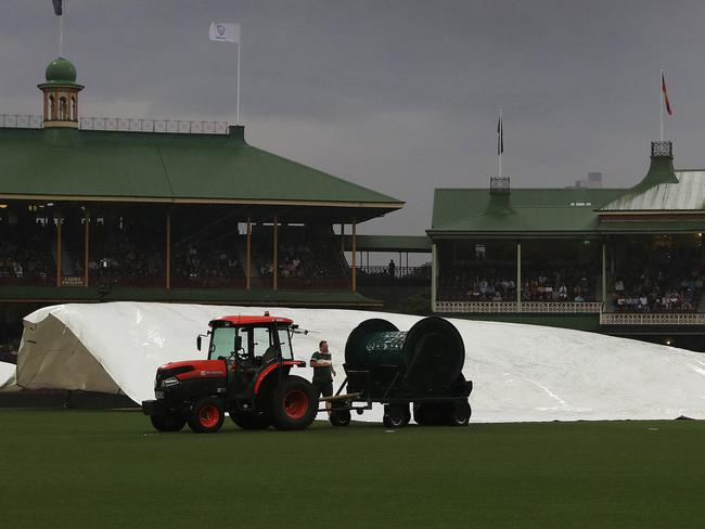 Rain stops play as groundsmen cover the pitch during the International T20 match between Australia and Pakistan at the SCG. Picture: Brett Costello