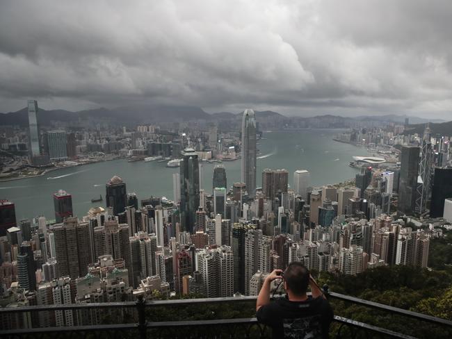 In this Sunday, Sept. 1, 2019 photo, a man sets up his camera in the Victoria Peak area to photograph Hong Kong's skyline. Life is not quite normal after three months of steady protests in the Asian financial center - and yet normal life goes on, as it must, for the cityâ€™s 7.4 million residents. (AP Photo/Jae C. Hong)