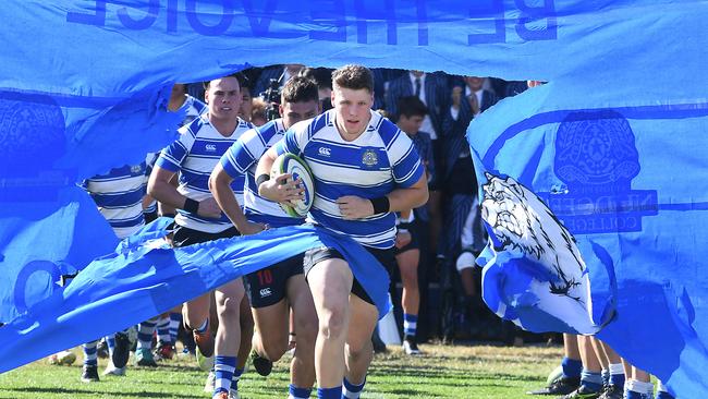 Nudgee College captain Harrison Vella break through the banner. Saturday August 3, 2018. Picture: AAP image/John Gass