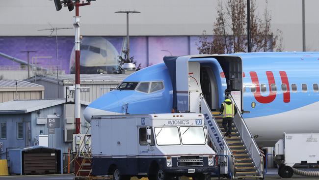 A worker walks up steps to the right of an avionics truck parked next to a Boeing 737 MAX 8 airplane being built for TUI Group at Boeing Co.'s Renton Assembly Plant in Renton, Washington. 