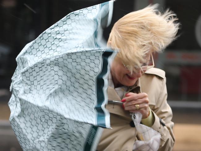 A sever storm still lashing Sydney has caused major damage to the electrical system .a wind blown woman in Bondi .pic john grainger