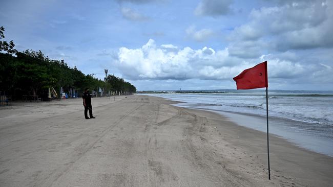 A Balinese security employee stand on a deserted beach in Kuta on Indonesia's resort island of Bali on May 29, Picture: AFP