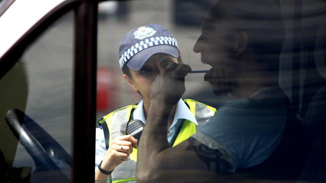 A police officer performs a road side random drug test.