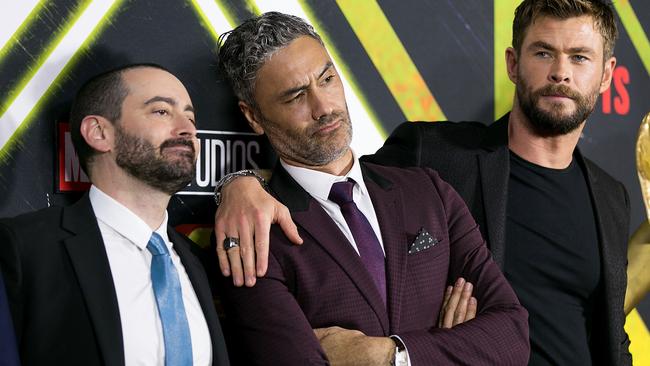 A Taika Waititi sandwich between executive producer Brad Winderbaum and Chris Hemsworth. (Photo by Caroline McCredie/Getty Images)