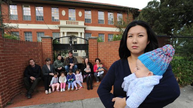 Anh Mai-Lane has started a campaign to open a co-ed 7-12 high school in Preston. Pictured with her son Marcus (4 months) and concerned residents. Picture: Andrew Henshaw
