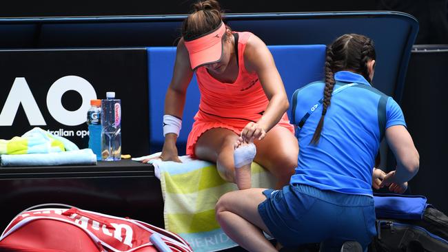 Lauren Davis receives medical attention against Simona Halep. Pic: AFP