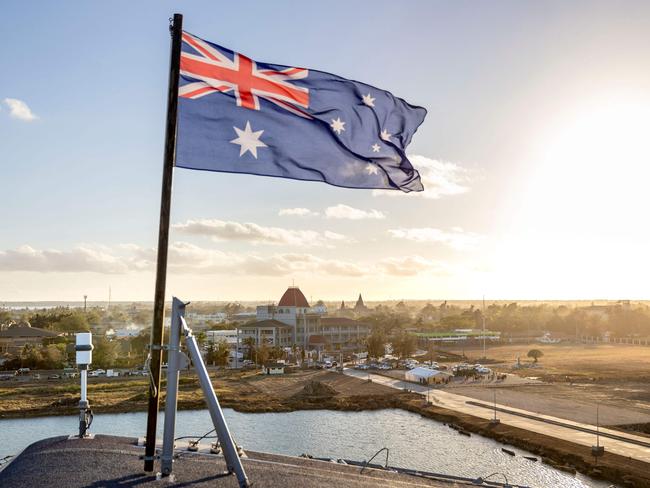 This handout photo taken on January 26, 2022 by the Australian Defence Force shows the Australian flag flying on board the HMAS Adelaide as the ship arrives in Nuku'alofa, Tonga, carrying disaster relief and humanitarian aid supplies following the January 15 eruption of the Hunga Tonga-Hunga Haâapai underwater volcano nearby. (Photo by CPL Robert Whitmore / Australian Defence Force / AFP) / -----EDITORS NOTE --- RESTRICTED TO EDITORIAL USE - MANDATORY CREDIT "AFP PHOTO / Australian Defence Force" - NO MARKETING - NO ADVERTISING CAMPAIGNS - DISTRIBUTED AS A SERVICE TO CLIENTS