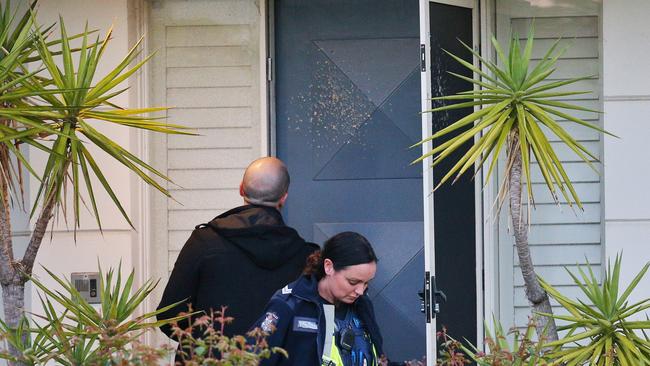 Police examine damage to a house in Port Melbourne that was shot at. Picture: Hamish Blair