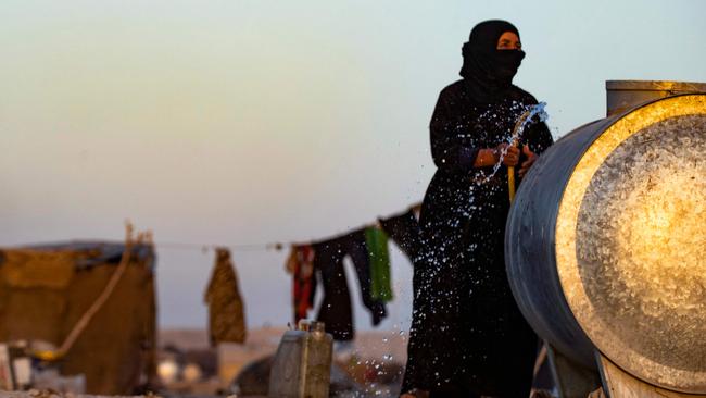 A Syrian woman fills a water container at the Sahlah al-Banat camp in Raqqa, in northern Syria. Picture: AFP