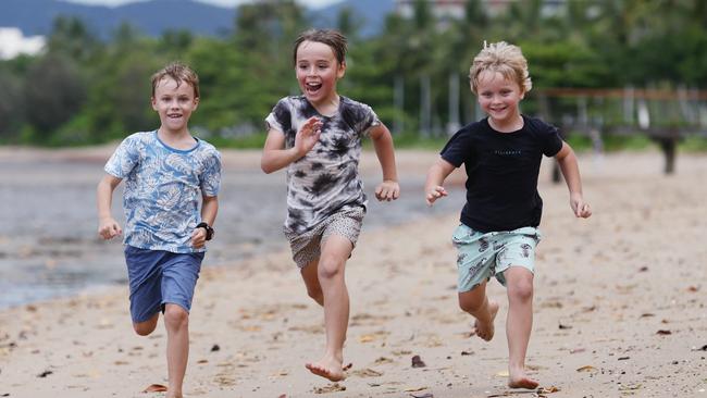 Alex Rudnik, 6, Alexander Saare, 8, and Oskar Saare, 5, work up a sweat running and playing together on the Cairns Esplanade beach on a hot weather day. Picture: Brendan Radke