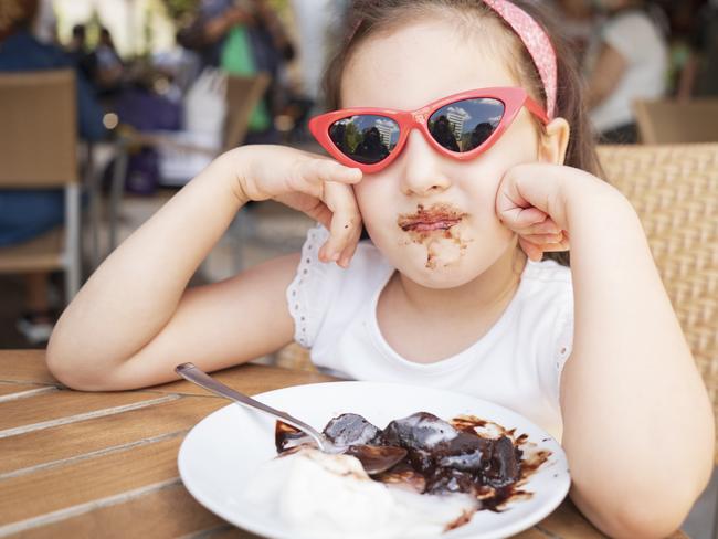 Cute little girl eating chocolate cake