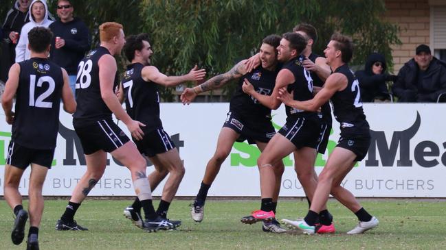 Gavin Shephard (middle) is surrounded by teammates after his crucial fourth-quarter goal against Unley Mercedes in round six. Picture: Kym Stegmeyer