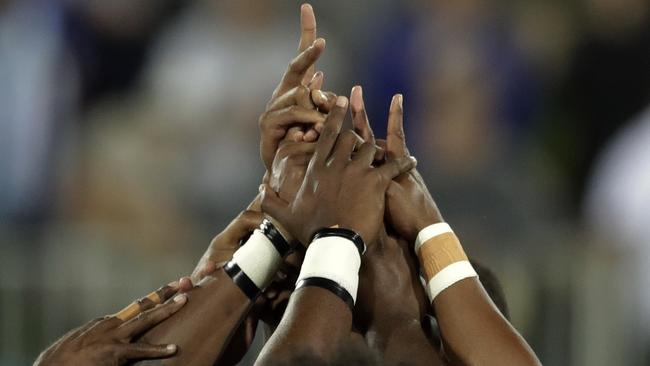 Fiji's players form a human ring after winning the men's rugby sevens gold medal.