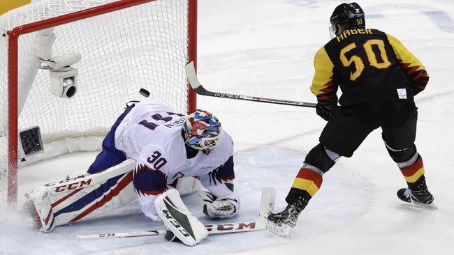 Patrick Hager (50), of Germany, shoots the puck past goalie Lars Haugen (30), of Norway, for a goal in the penalty shootout. Picture: AP.