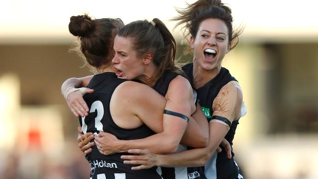 Jasmine Garner is congratulated by Alicia Eva and Stephanie Chiocci after kicking the first goal in AFLW history.