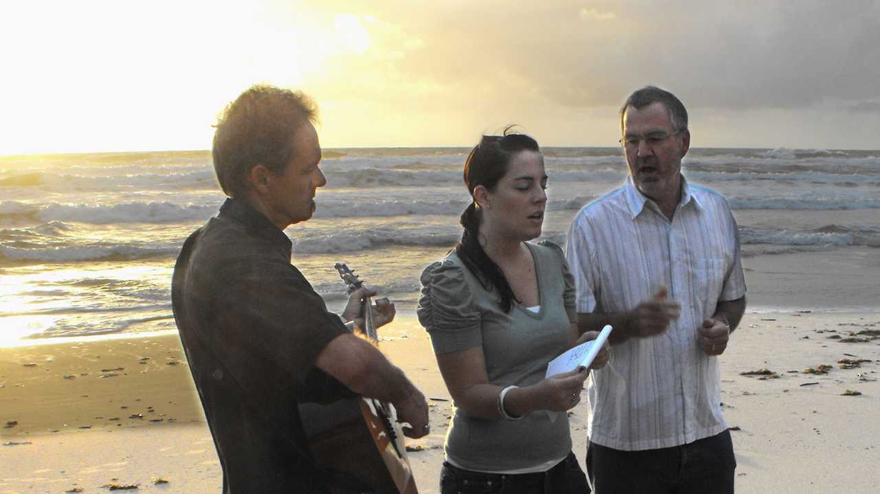 Pastors Steve Nichol and Ashleigh McKenzie and Ashleigh's daughter Heather sing at the Resurrection Sunday dawn service at Coolum Beach. Photo: Lesley Clark. Picture: Lesley Clark