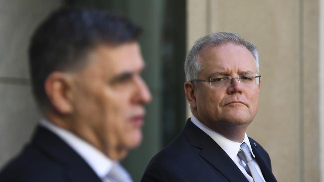 Australian Prime Minister Scott Morrison, right, listens to Australia's Chief Medical Officer Brendan Murphy as he speaks to the media during a press conference. Picture: Lukas Coch/AAP