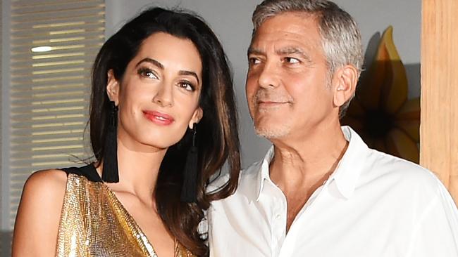 Amal Clooney dazzles in gold dress – and George can't take his