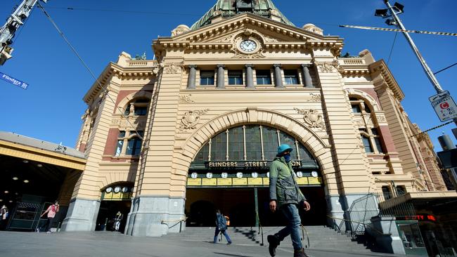 Flinders Street Station, normally crammed with people, is almost deserted. Picture: Andrew Henshaw