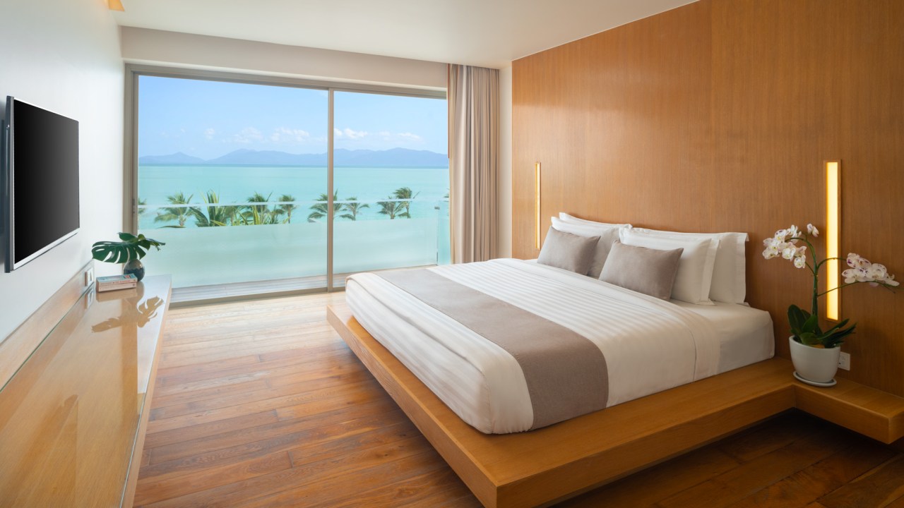 <h2>The room</h2><p><span>I am in a top floor Deluxe Sea View Suite, which has a bedroom, separate living room and a kitchenette, with the decor in wooden tones along with crisp white linen bedding and curtains. It&rsquo;s a simple look that leaves the heavy lifting to the gorgeous views stretching across the water to the misty outline of Koh Pha-Ngan in the distance. The only thing out of place in the minimalistic room is the lumpy blue sofa and a work bench without a chair to sit at it. Maybe that&rsquo;s the point &ndash; bypass by the work area and relax on to the balcony instead?</span></p>