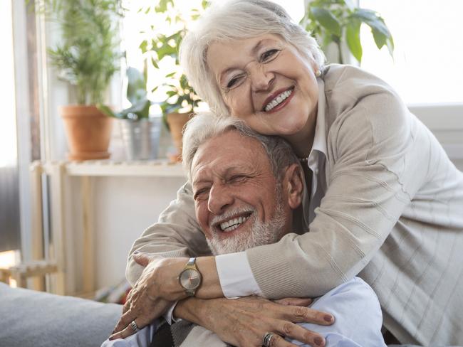 SENIOR/PENSIONER/MATURE/ELDERLY/OVER 65/GRANDPARENT/RETIREE/SUPERANNUATION. Picture: istock Woman embracing husband sitting on the couch