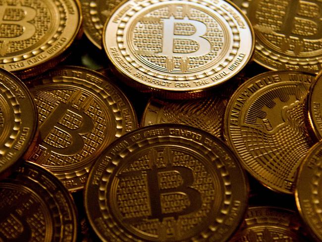 (FILES):  This file photo taken in Washington, DC, on May 1, 2014 shows bitcoin medals.  Bitcoin burst out of the shadows in 2017, seducing Wall Street and individual investors alike even though many still struggle to understand precisely what it is. The cryptocurrency's rise is also pushing regulators to consider taking action after years of simply urging caution.  / AFP PHOTO / Karen BLEIER