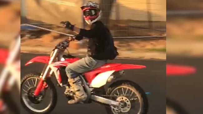 A monkey bike hoon sticks his finger up as he rides past. 